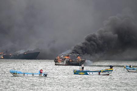 Im Hafen von Manta stehen mehrere Fischerboote in Flammen.