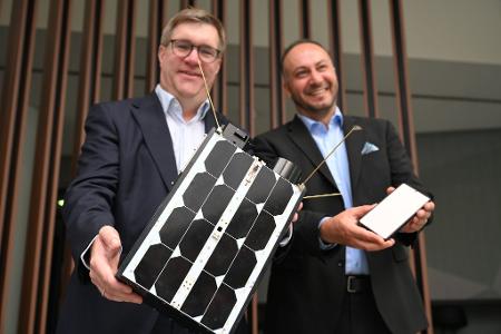Demonstrativ gute Laune von O2-Manager Jörg Kablitz und OQ-Chef Omar Qaise, die bei der Vorstellung ihres Vorhabens ein Modell eines Satelliten dabeihatten. 