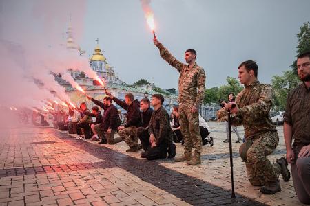 Menschen zünden Fackeln während der Beerdigungszeremonie für einen gefallenen ukrainischen Soldaten in Kiew.