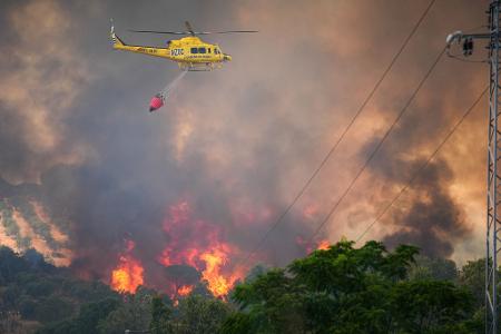 Ein Hubschrauber ist bei einem Waldbrand in Spanien am Odiel-Fluss in der Gemeinde Gibraleón im Einsatz.