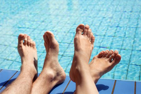 Gepflegte Männer- und Frauenfüße im Schwimmbad