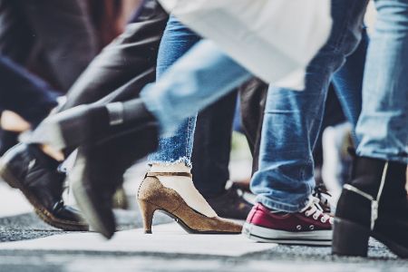 Schuhe von durch eine Stadt eilenden Menschen
