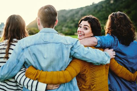 Gruppe junger Leute umarmt sich in der Natur