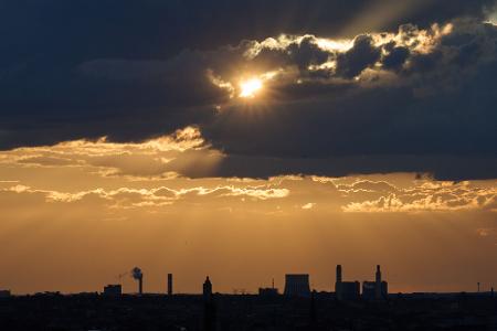 Die Sonne bricht über Berlin durch die Wolken.