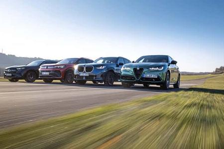 Vier Mittelklasse-SUVs – Mercedes GLC 220d 4Matic, BMW X3 xDrive 20d, Alfa Romeo Stelvio 2.0 Diesel und VW Tiguan 2.0 TDI – fahren nebeneinander auf einer Landstraße.