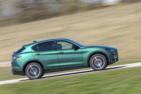 Alfa Romeo Stelvio 2.0 Diesel SUV in grüner Lackierung, fahrend auf einer Landstraße, Seitenansicht.