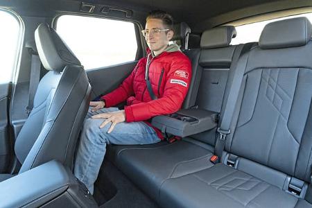 Innenraumaufnahme eines BMW X3 xDrive 20d mit einer Person auf der Rückbank. Die Aufnahme zeigt die Beinfreiheit und das Sitzplatzangebot im Fond.