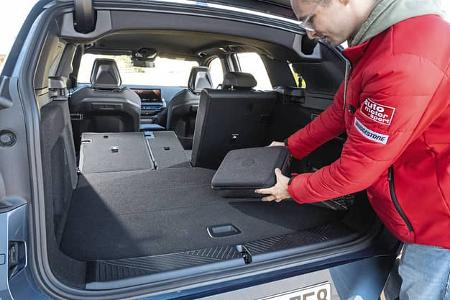 BMW X3 xDrive 20d, Kofferraum mit umgeklappter Rückbank, Person lädt Gepäck ein.