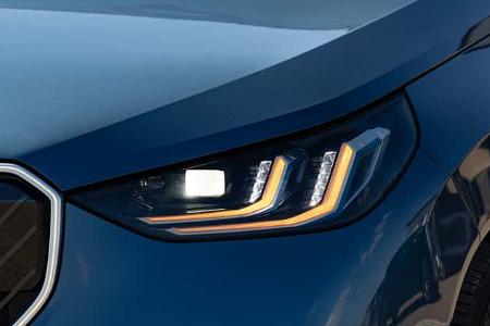 Detailaufnahme des LED-Scheinwerfers eines BMW X3 xDrive 20d in blauer Lackierung. Die Aufnahme zeigt die markante Lichtsignatur und den vorderen Kotflügel.