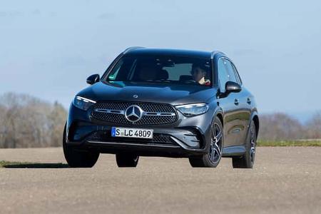 Mercedes GLC 220d 4Matic fährt auf einer asphaltierten Fläche, frontal fotografiert, mit Fahrer im Innenraum.