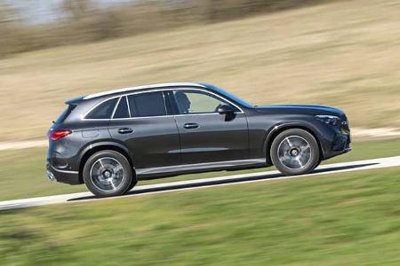Mercedes GLC 220d 4Matic SUV fährt auf einer Landstraße, Seitenansicht, dynamische Bewegung, Tageslicht.