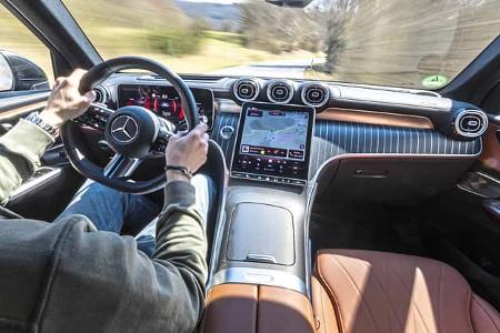 Innenraumaufnahme eines Mercedes GLC 220d 4Matic während der Fahrt, Fokus auf Cockpit, Lenkrad und Infotainmentsystem.