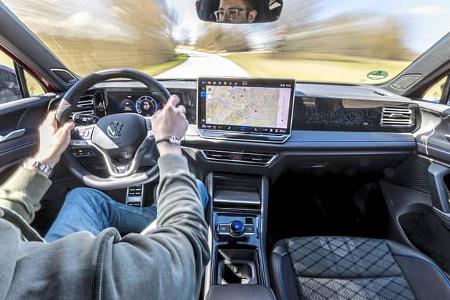 Innenraum des VW Tiguan 2.0 TDI während der Fahrt, Blick aus Fahrersicht auf Cockpit, Lenkrad und Infotainment-Display.