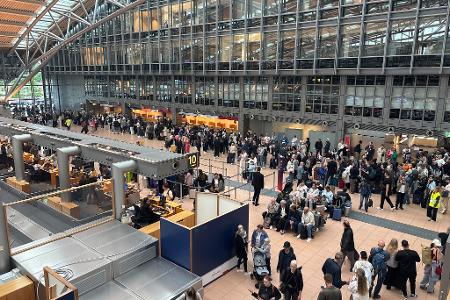 Zahlreiche Menschen stehen im Terminal des Hamburger Flughafens.