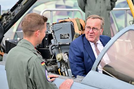 Ein Bundeswehr-Soldat zeigt dem Minister auf der ILA einen Tornado-Simulator. 