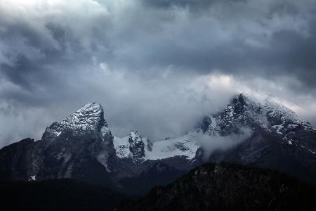 Wolkenverhangen ist der schneebedeckte Watzmann.