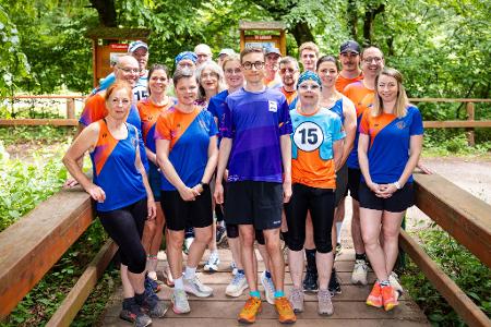 Fynn Thome (18, Mitte) posiert gemeinsam mit den Mitgliedern der Lauf- und Triathlonfreunde Lebach (LTF Theeltal) für ein Gruppenfoto.