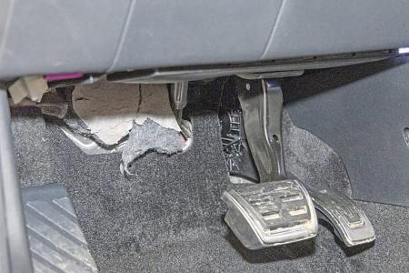 Detailaufnahme des Fußraums und der Pedalerie eines Skoda Karoq, Modelljahr 2018, mit sichtbarer Teppich- und Verkleidungsschädigung.