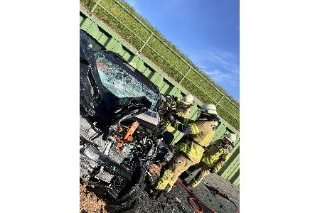 Einsatzkräfte der Feuerwehr Bremerhaven befreien den schwer verletzten Fahrer mit hydraulischem Rettungsgerät aus dem stark deformierten Elektrofahrzeug.
