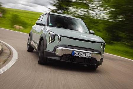 Kia EV2 auf Landstraße in Kurvenfahrt, Frontalansicht, dynamische Bewegungsunschärfe im Hintergrund.
