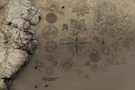Menschen versammeln sich am Ocean Beach in San Francisco, um bei einer von Künstler Andres Amador organisierten Veranstaltung Kunstwerke im Sand zu gestalten.