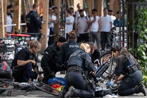 Polizisten knien in der Nähe des Frankfurter Hauptbahnhofs am Boden und kümmern sich um einen Verletzten. 