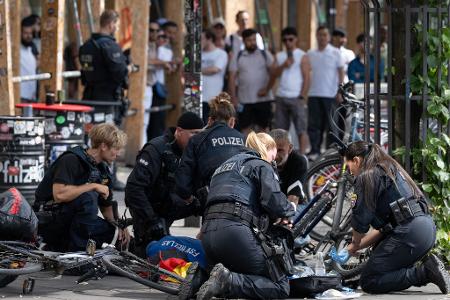 Polizisten knien in der Nähe des Frankfurter Hauptbahnhofs am Boden und kümmern sich um einen Verletzten. 