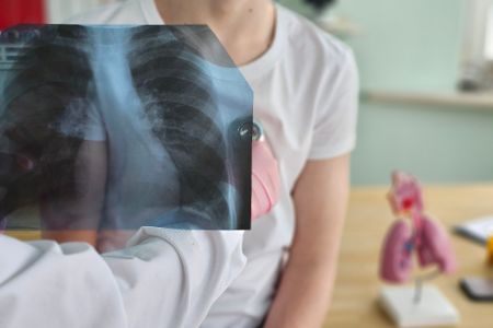 Arzt untersucht Patient mit Röntgenbild in der Hand