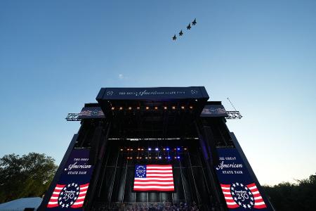 Die versammelte Menge sah in Formation fliegende Kampfjets am Himmel. 