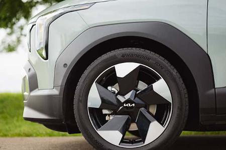 Detailaufnahme des Vorderrads und Kotflügels eines Kia EV2 RG26. Sichtbar sind das stylisierte Leichtmetallrad, der Reifen Hankook iON evo und der vordere Kotflügel mit Scheinwerferpartie.