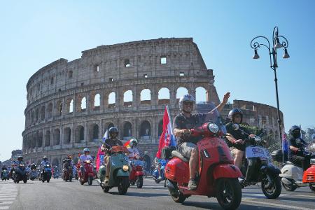 Vespa-Fans fahren am Kolosseum vorbei.