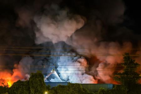 Einsatzkräfte der Feuerwehr bekämpfen den Brand in einem Gewerbegebiet in Stuttgart.