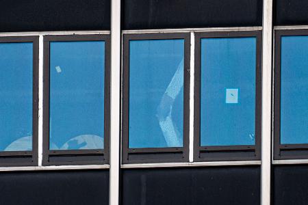 Ein eingeknickter Stützpfeiler ist durch ein Fenster zu sehen.