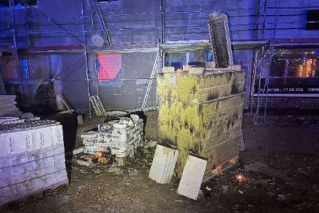 Unbekannte entzündeten Paletten mit Baumaterialien