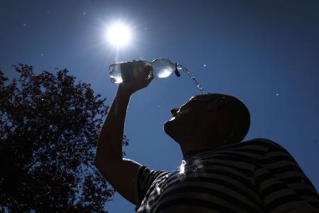 Zeitz für eine Abkühlung: Ein Mann schüttet sich im bayerischen Kaufbeuren Wasser auf den Kopf.