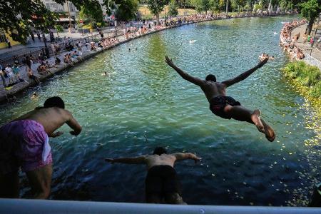 Während einer Hitzewelle springen Menschen in Paris von einer Brücke in den Canal Saint-Martin.