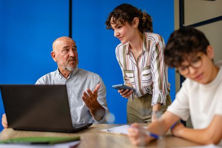 Menschen unterschiedlichen Alters vor einem Laptop