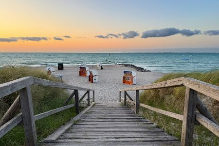 Holztreppe Richtung Ostseestrand hinunter mit Strandkörben vor dem Wasser