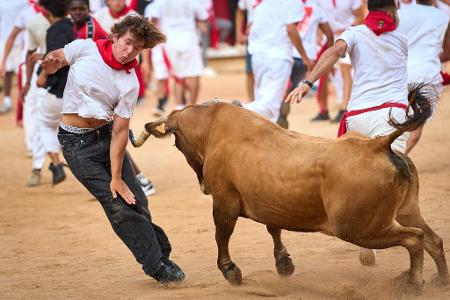 Ein Festbesucher weicht in der Stierkampfarena einem Kalb aus, nachdem beim San-Fermin-Fest der achte Stierlauf stattgefunden hat.