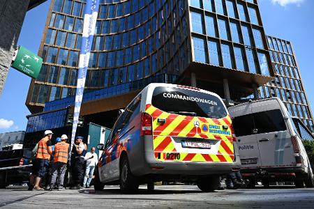 Einsatzkräfte stehen vor dem Gebäude bei einem Brand in der Brüsseler Innenstadt.