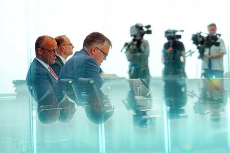 Bundeskanzler Friedrich Merz (l, CDU) sitzt bei der traditionellen Sommer-Pressekonferenz im Haus der Bundespressekonferenz (BPK) neben Regierungssprecher Stefan Kornelius (vorne, 3.v.l).