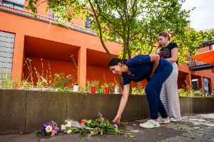 Menschen kommen vorbei und legen Blumen ab.