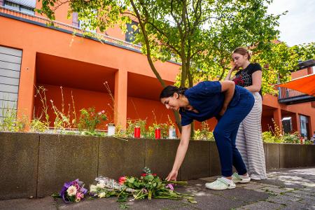 Menschen kommen vorbei und legen Blumen ab.