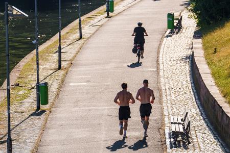 Zeigefreudige Männer mit nacktem Oberkörper und kurzer Hose beim Joggen. (Archivbild)