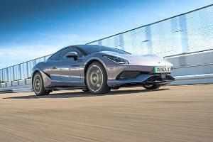 Sportwagen Denza 03 in Fahrt auf einer abgesperrten Teststrecke, aufgenommen bei Tageslicht aus niedriger Perspektive.