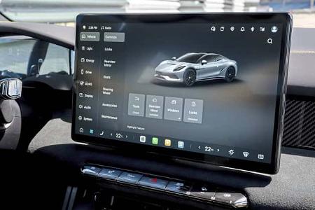 Zentraldisplay eines modernen Fahrzeugs mit Fahrzeugmenü und digitalem Fahrzeugabbild im Cockpit.