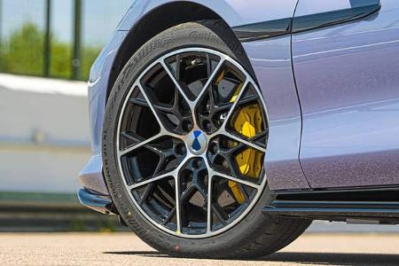 Detailaufnahme eines Pkw-Vorderrads mit sportlicher Felge, gelbem Bremssattel und Continental-Reifen.
