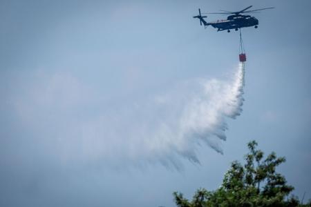 Ein Bundeswehr-Hubschrauber wirft Löschwasser über einem Waldbrand im Müritz-Nationalpark ab