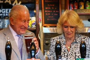 König Charles III. zapft Bier und witzelt über das WM-Aus