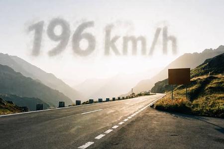 Der Sustenpass in der Schweiz im Sonnenuntergang, es spiegelt sich das Licht in der Straße auf dem kein Auto fährt, im Himmel darüber erscheint als Wolke 